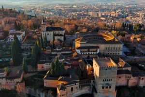 Aerial view of the Alhambra fortress and palaces in Granada, Spain, with the city spreading out in the background.