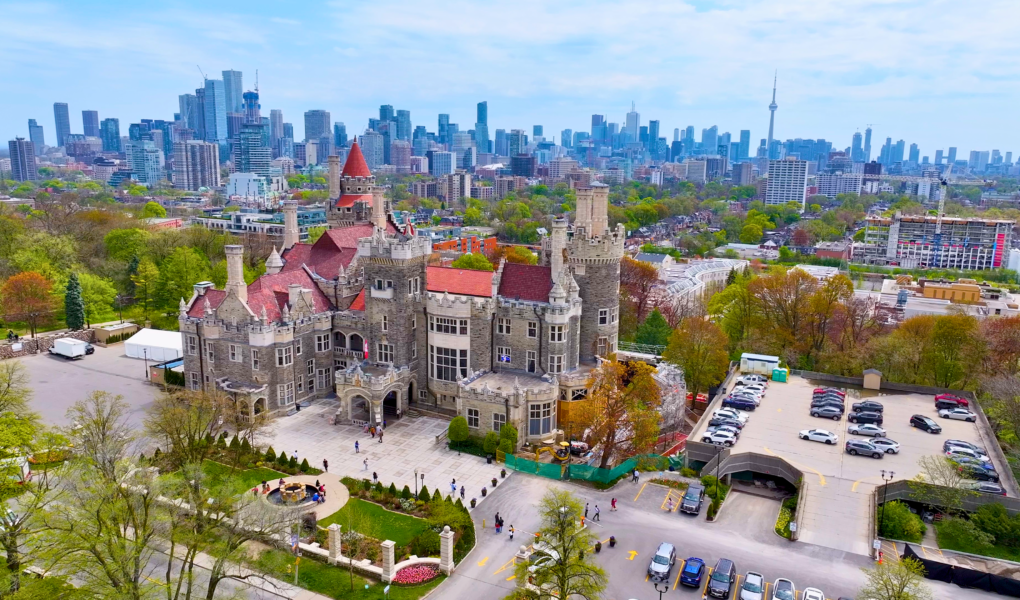 Aerial view of Casa Loma with the Toronto skyline in the background on a clear spring day.