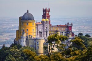 Pena palace stands high on a forested hilltop in Sintra, Portugal, showcasing vibrant architecture.
