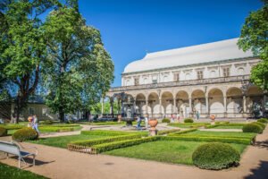 People strolling in Prague Castle gardens under clear blue sky