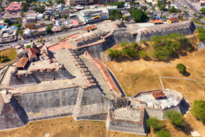 Aerial view of Castillo San Felipe de Barajas fortress in Cartagena, Colombia, surrounded by city buildings.