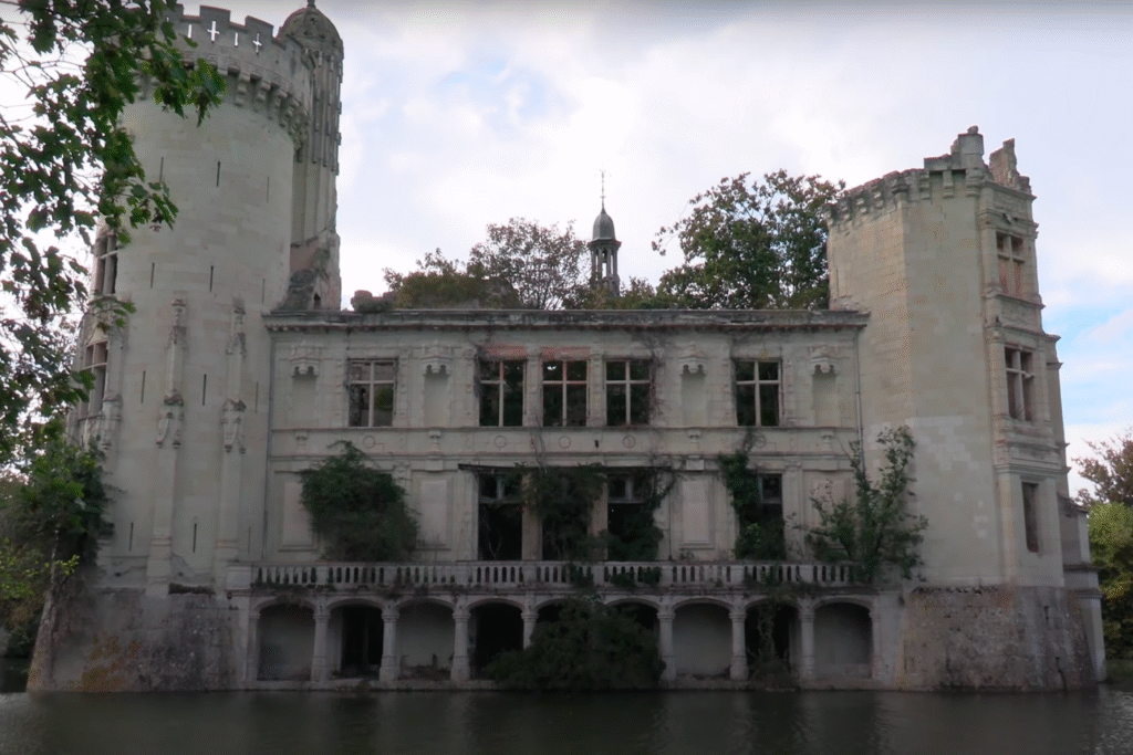 Ruinen von Schloss La Mothe-Chandeniers mit Wasser und bewachsenen Fassaden