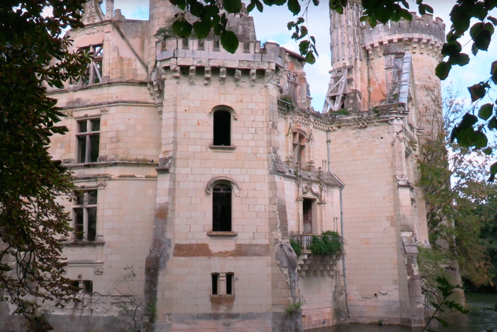 Close-up view of the deteriorating walls and balcony of la Mothe-Chandeniers, showcasing its Gothic detailing and signs of structural decay.
