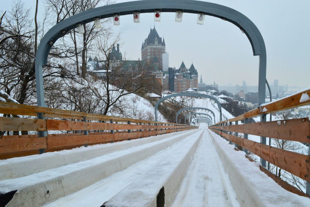 View of Fairmont Le Château Frontenac from the top of the historic Toboggan Slide in Québec City, Canada, during winter with snow-covered surroundings.