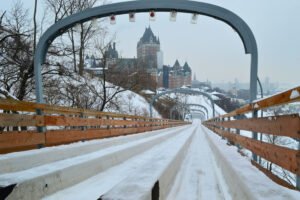 View of Fairmont Le Château Frontenac from the top of the historic Toboggan Slide in Québec City, Canada, during winter with snow-covered surroundings.