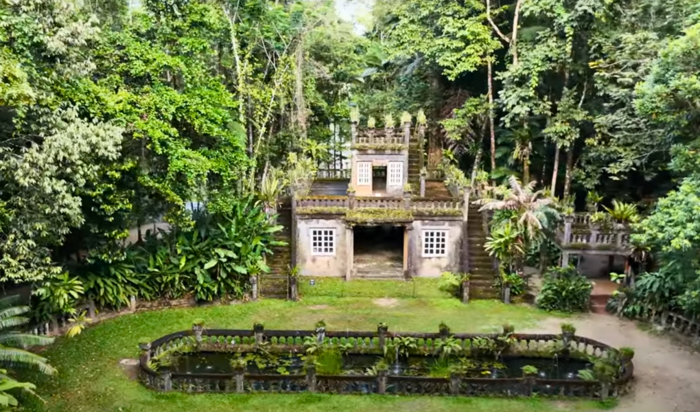 Paronella Park Castle framed by lush rainforest, showcasing the romantic ruins and reflection pond in the heart of Queensland, Australia.