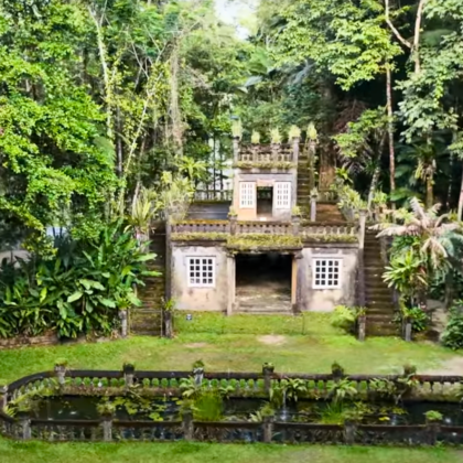 Paronella Park Castle framed by lush rainforest, showcasing the romantic ruins and reflection pond in the heart of Queensland, Australia.