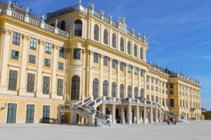 Close-up of Schönbrunn Palace’s grand rear façade with its elegant staircase and classical statues under a clear blue sky.