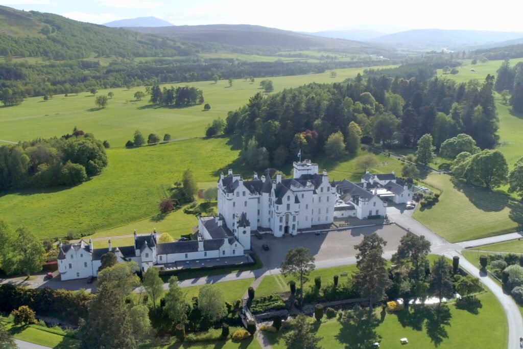 Aerial view of Blair Castle surrounded by lush Highland scenery and rolling green landscapes in Perthshire, Scotland