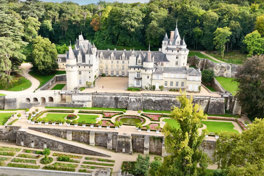 Aerial view of Château d’Ussé with formal gardens, round towers, and wooded surroundings—believed to have inspired Sleeping Beauty