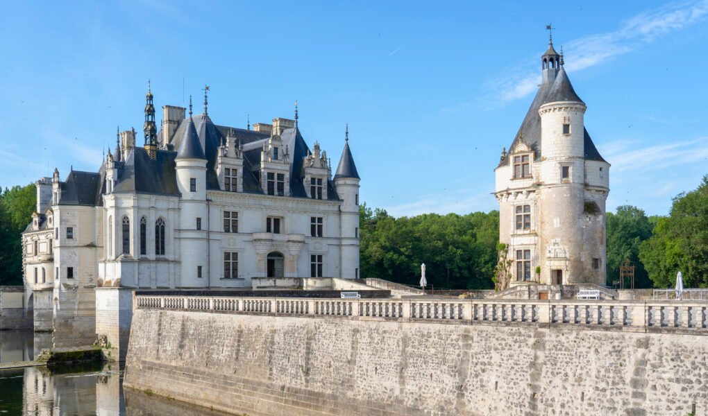 Château de Chenonceau in early morning light with a clear reflection on the River Cher and forested backdrop