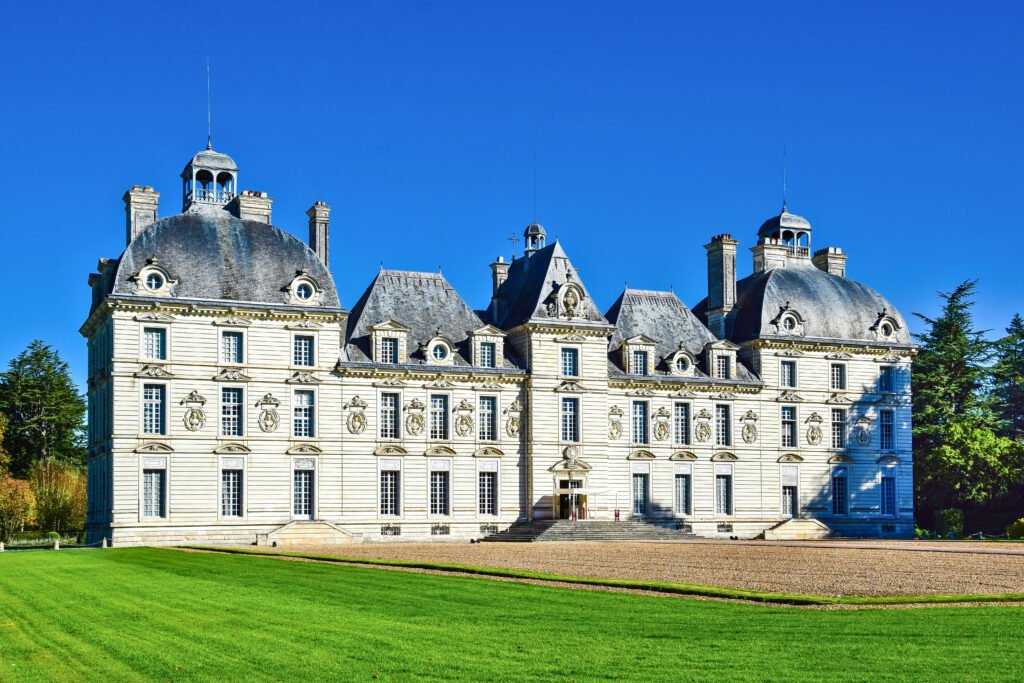 Château de Cheverny with its symmetrical classical facade and manicured lawn under a bright blue sky
