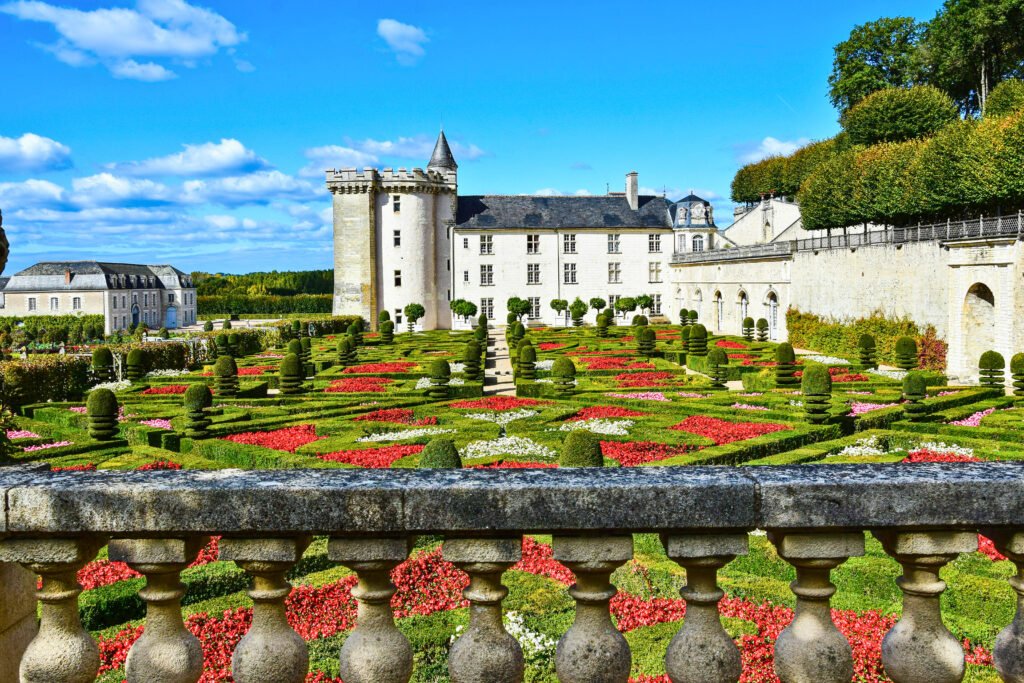 View of Château de Villandry with its vibrant Renaissance gardens filled with red and white flower beds
