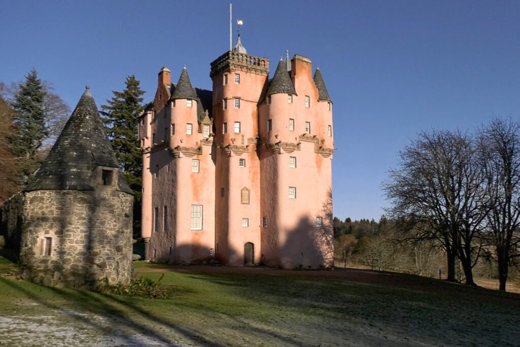 Pink fairytale-like Craigievar Castle standing under a clear blue sky in Aberdeenshire, Scotland