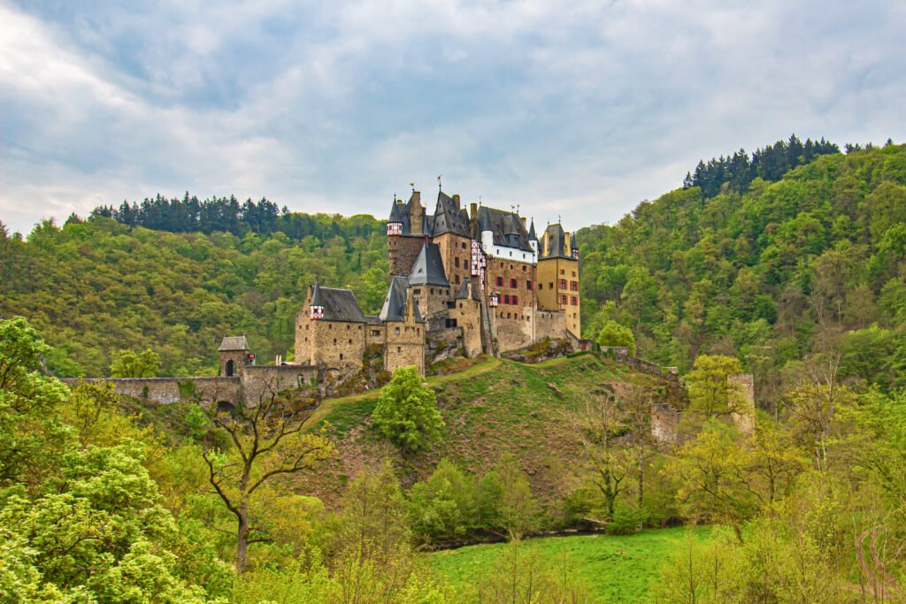 Eltz Castle in spring surrounded by fresh green forest and rolling hills in Germany
