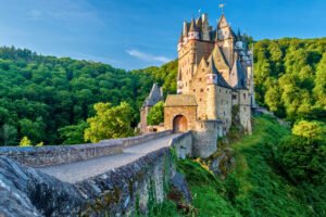Eltz Castle nestled in lush green hills, German fortress landscape.