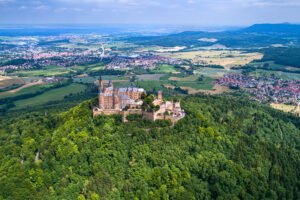 Aerial view of Hohenzollern Castle on a lush hilltop, focus keyword Hohenzollern Castle.