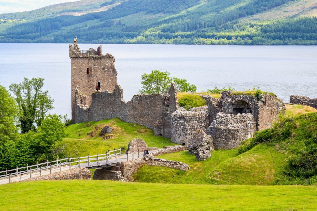 Ruins of Urquhart Castle overlooking the calm waters of Loch Ness in the Scottish Highlands