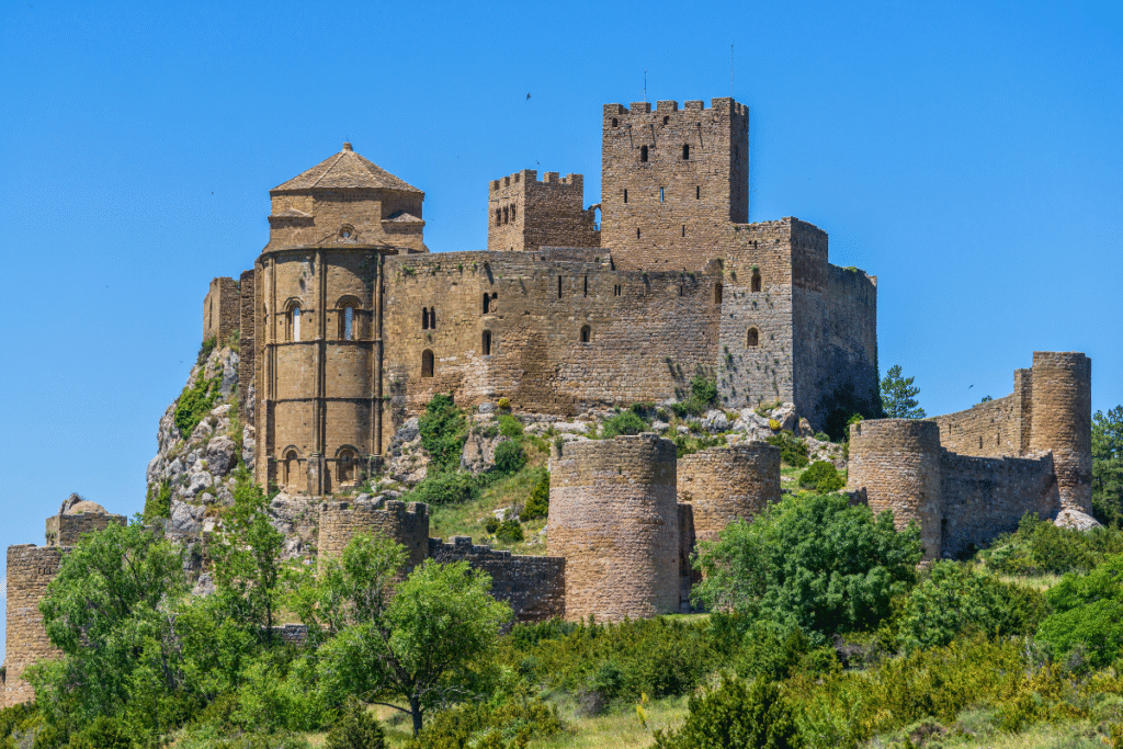 Medieval Castle of Loarre with stone towers and walls on a rocky hillside in Spain
