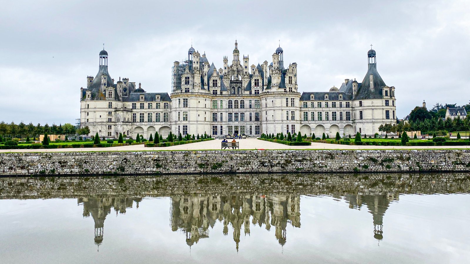 O Castelo de Chambord com seu reflexo magnífico no fosso em um dia nublado.