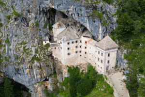 Aerial view of Predjama Castle built into a limestone cliff in Slovenia.
