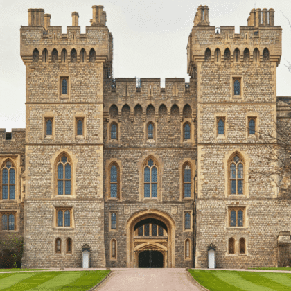 Front view of Windsor Castle’s main entrance, with symmetrical towers, stone walls, and manicured lawns.