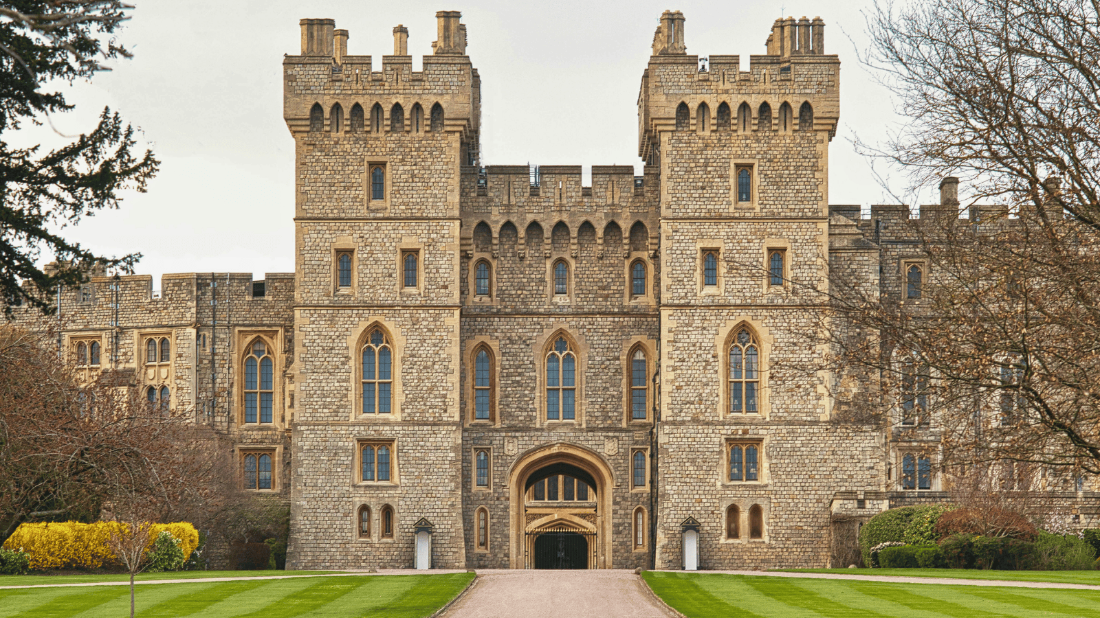 Front view of Windsor Castle’s main entrance, with symmetrical towers, stone walls, and manicured lawns.