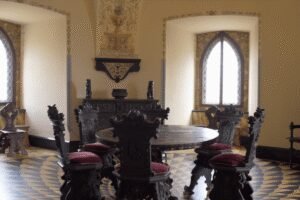 Ornate medieval dining room inside Bojnice Castle Slovakia with carved chairs and gothic windows.