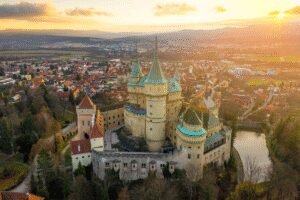 Aerial view of Bojnice Castle Slovakia surrounded by a town at sunset.