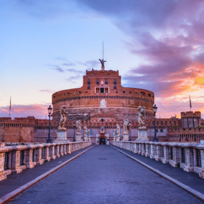 Castel Sant'Angelo at sunset with angel statues and colorful sky in Rome