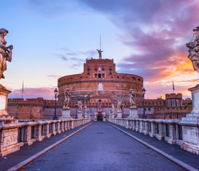 Castel Sant'Angelo at sunset with angel statues and colorful sky in Rome