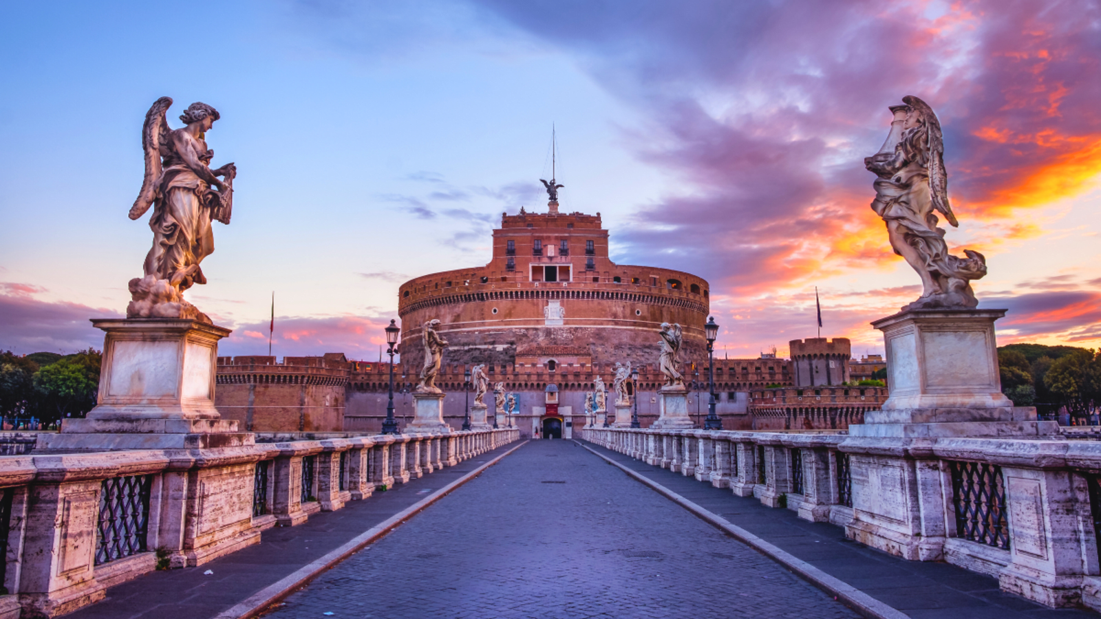 Castel Sant'Angelo at sunset with angel statues and colorful sky in Rome