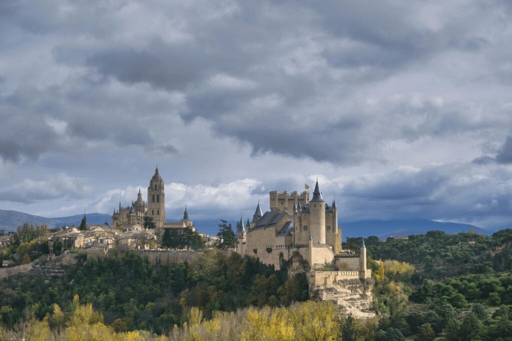 Alcazar of Segovia castle on a hilltop amid dramatic clouds in Spain