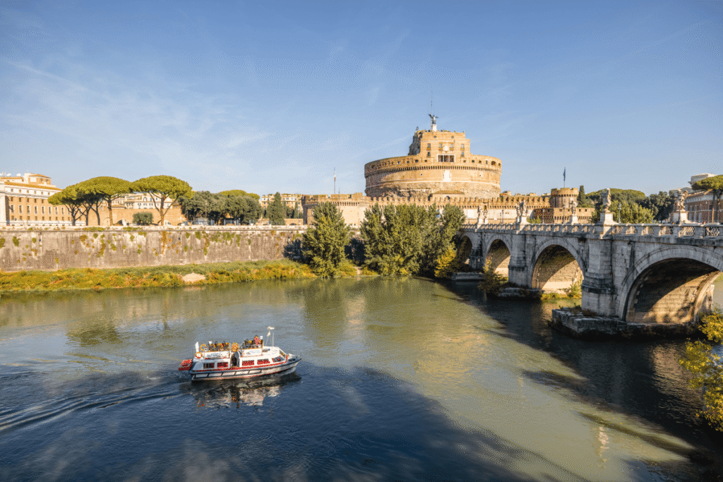 Tourist boat on Tiber River with Castel Sant'Angelo in the background.