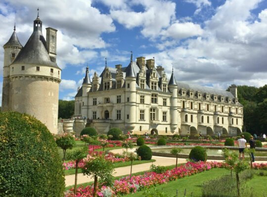 Beautiful gardens and Chenonceau Castle under a blue sky in France
