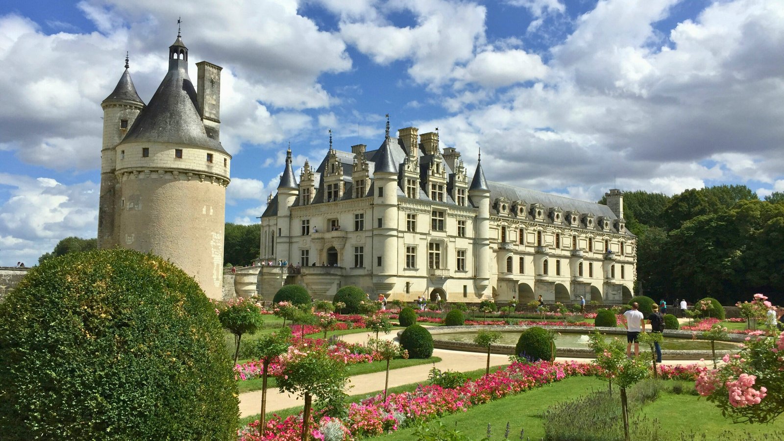 Beautiful gardens and Chenonceau Castle under a blue sky in France