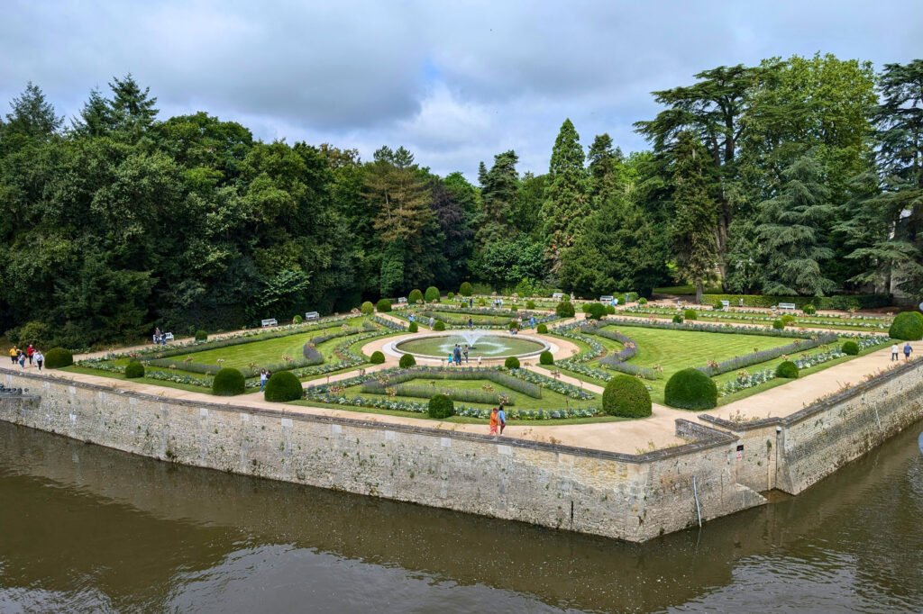 Château de Chenonceau gardens with central fountain and lush landscaping.