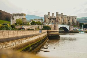 Conwy Castle beside the River Conwy with arched road bridge in North Wales.