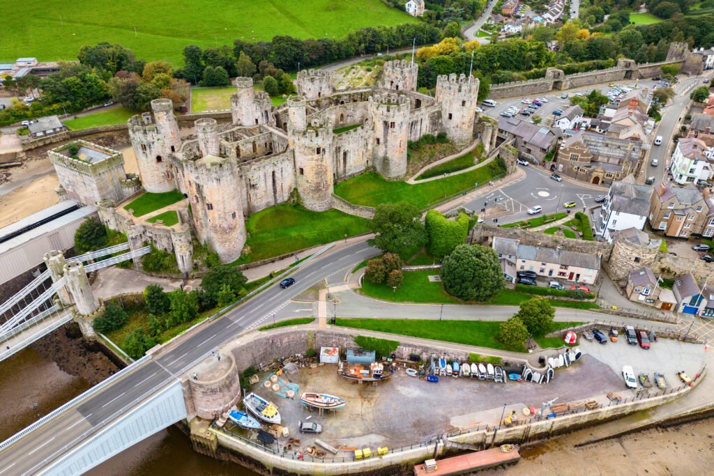 Aerial view of Conwy Castle, medieval fortress by the river and town walls in North Wales.