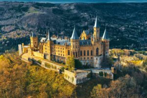 Aerial view of Hohenzollern Castle, an iconic fortress atop a forested hill.