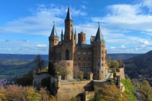Hohenzollern Castle atop a hill, overlooking forests and valleys.