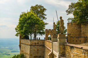 Hohenzollern Castle with statues and scenic valley, Germany’s historic hilltop fortress