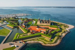 Aerial panorama of Kronborg Castle in Helsingør, Denmark, ringed by fortified ramparts beside the Øresund Strait.