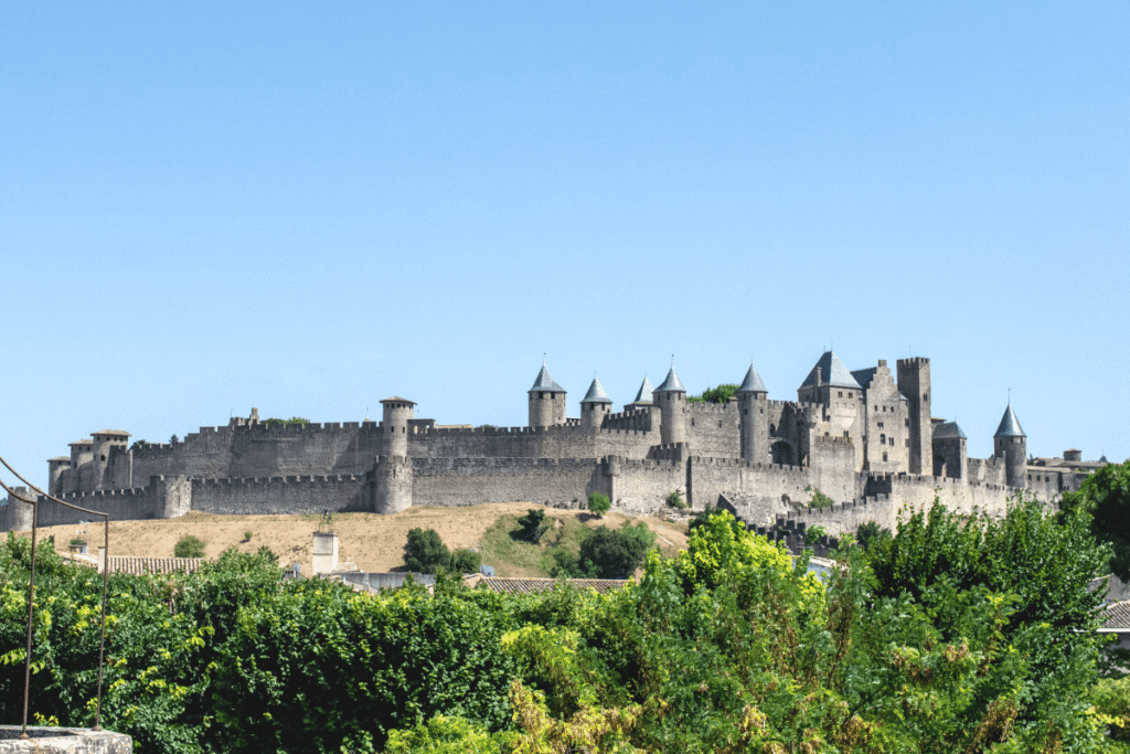 Carcassonne Castle with stone towers under blue sky, medieval architecture in France.