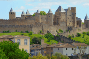 View of Carcassonne Castle, medieval fortress with towers, historic walls, and nearby village homes.