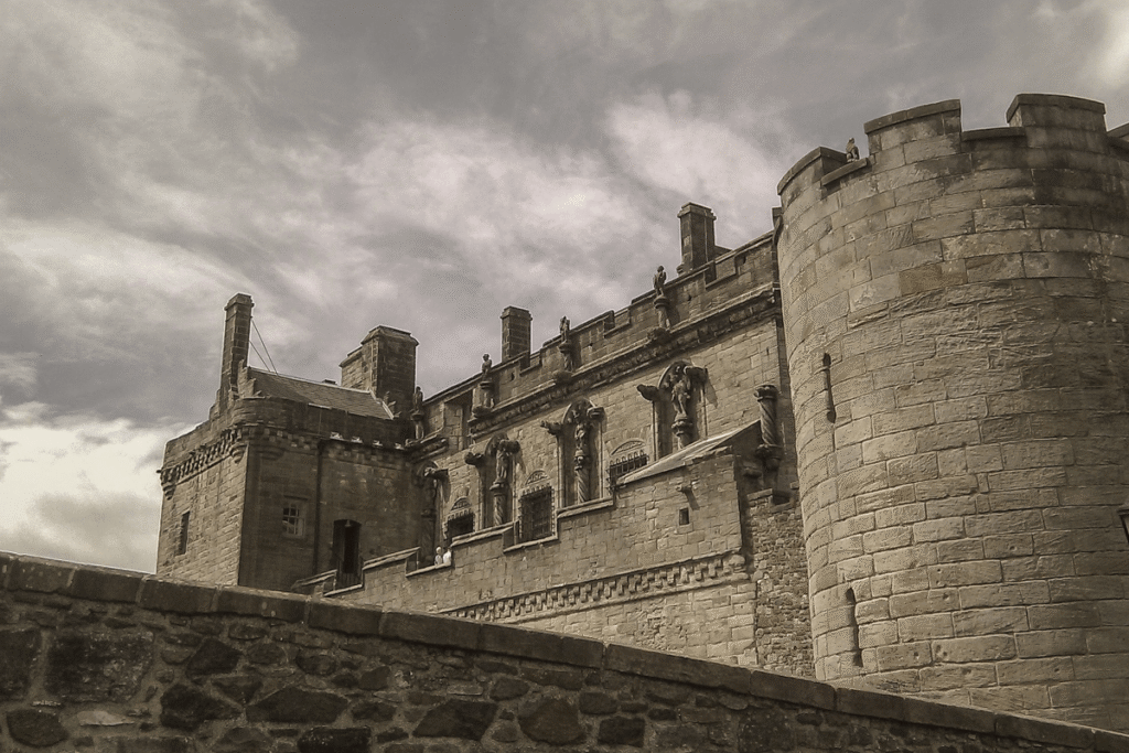 Stirling Castle with grand stone towers under cloudy Scottish sky.