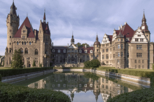 Moszna Castle with reflection in water, iconic fairytale architecture in Poland.