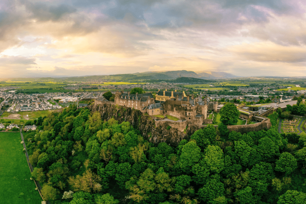 Aerial view of Stirling Castle on a hilltop in Scotland's lush landscape.