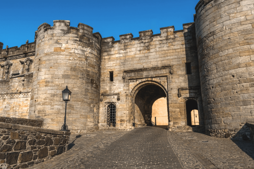 Main gate of Stirling Castle under blue sky, iconic Scottish stronghold