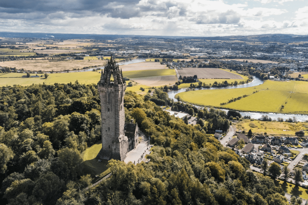 Aerial view of Wallace Monument amid Stirling countryside, Scotland, iconic Scottish heritage site.